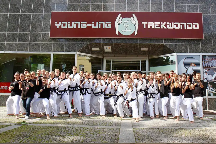 Trainerakademie: Viele Trainer Posieren für ein Gruppenfoto im Taekwondo Kampfanzug