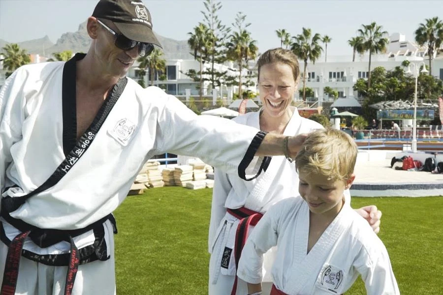 Taekwondo Großmeister beim Training mit Kind im Taekwondo-Camp