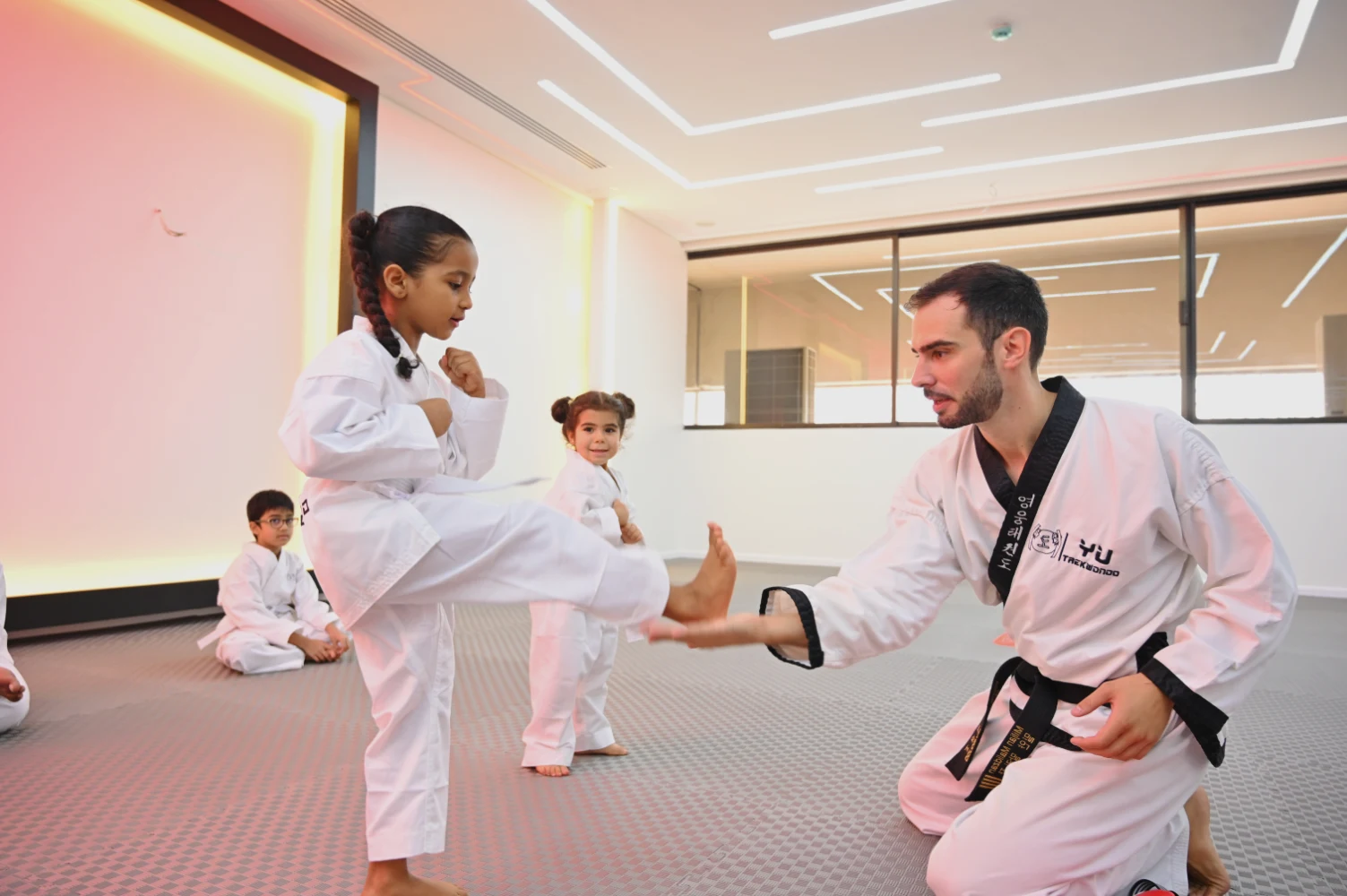 Ein Kind das mit dem Taekwondo trainer trainiert